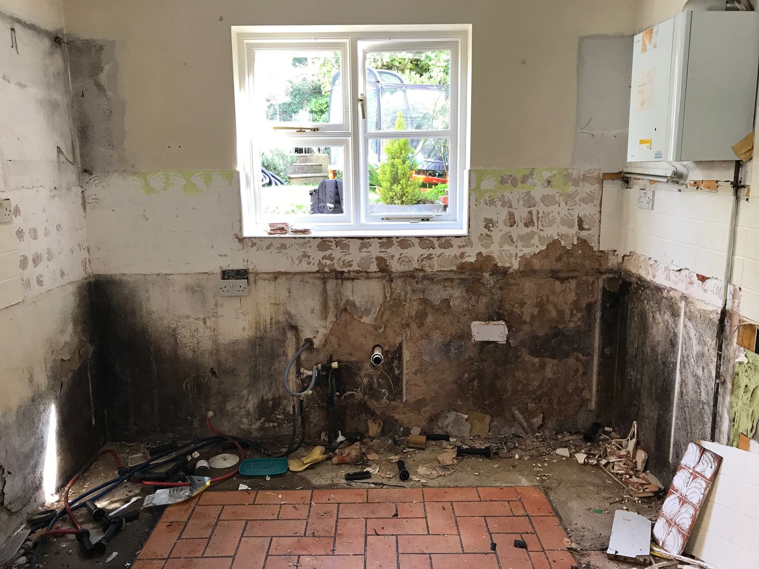 Damp plaster stripped back to the wall