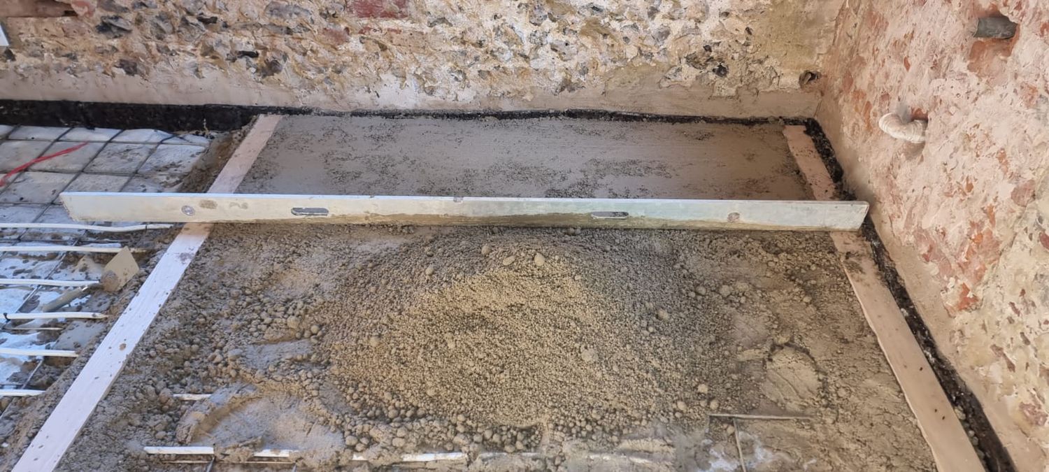 Limecrete floor installation, mixture being levelled & compressed