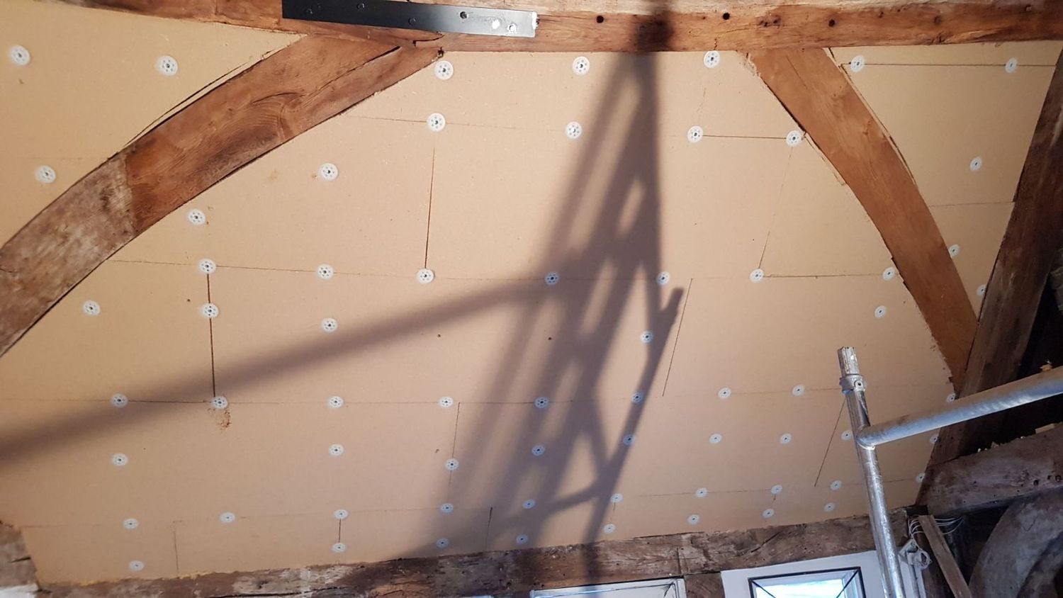 Wood fibre insulation boards cut & fixed under rafters leaving oak structure exposed