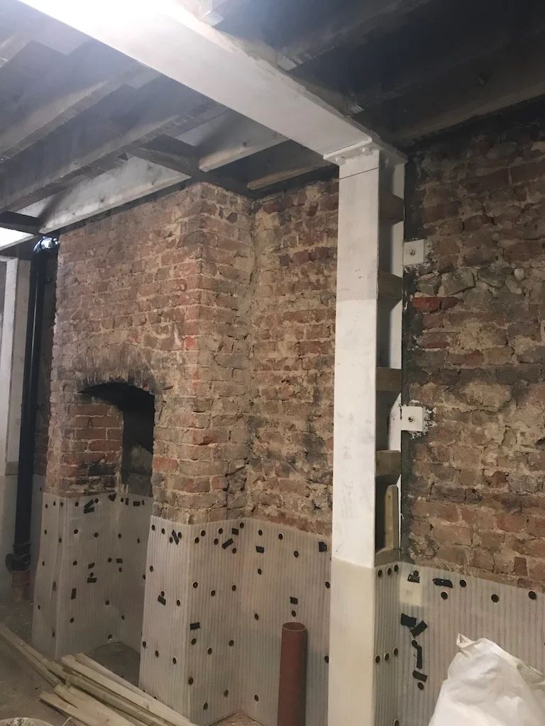 Render taken down to bare brickwork, structural beam and column in place