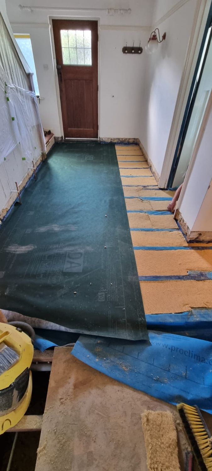 Hallway suspended floor is getting insulated with Pro Clima Solitex plus, Gutex thermoflex wood fibre insulation,and Pro Clima DA membrane