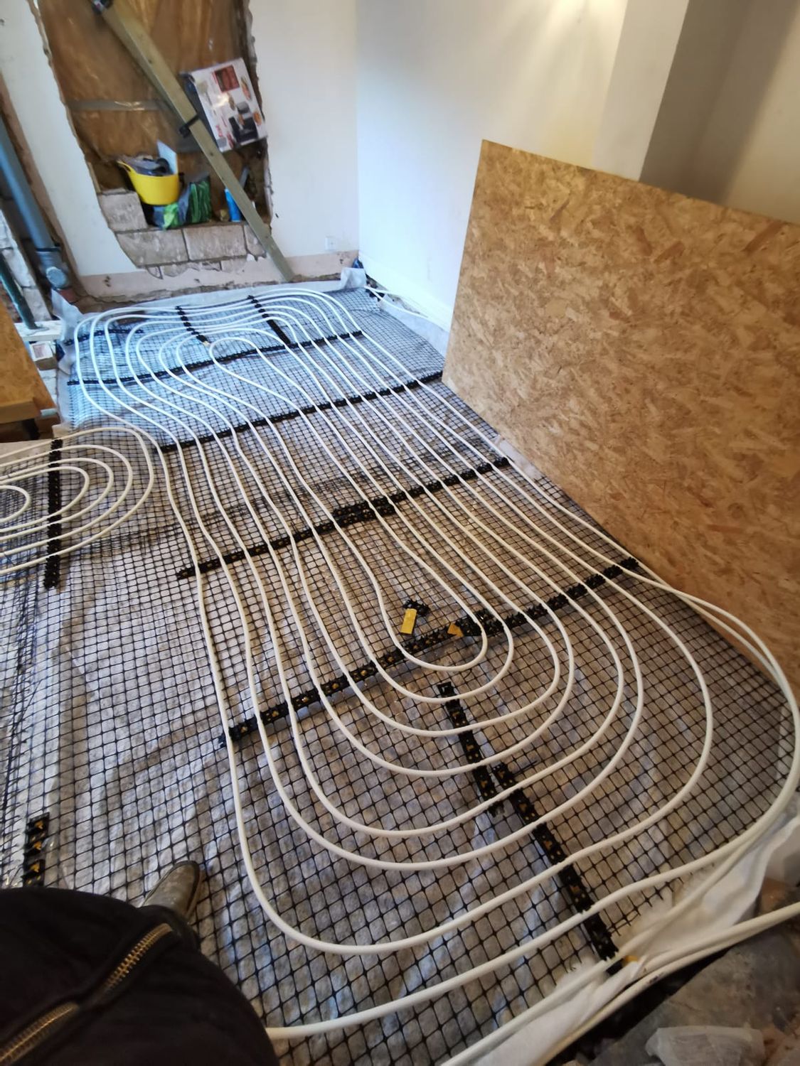 Wet underfloor heating pipes being laid down