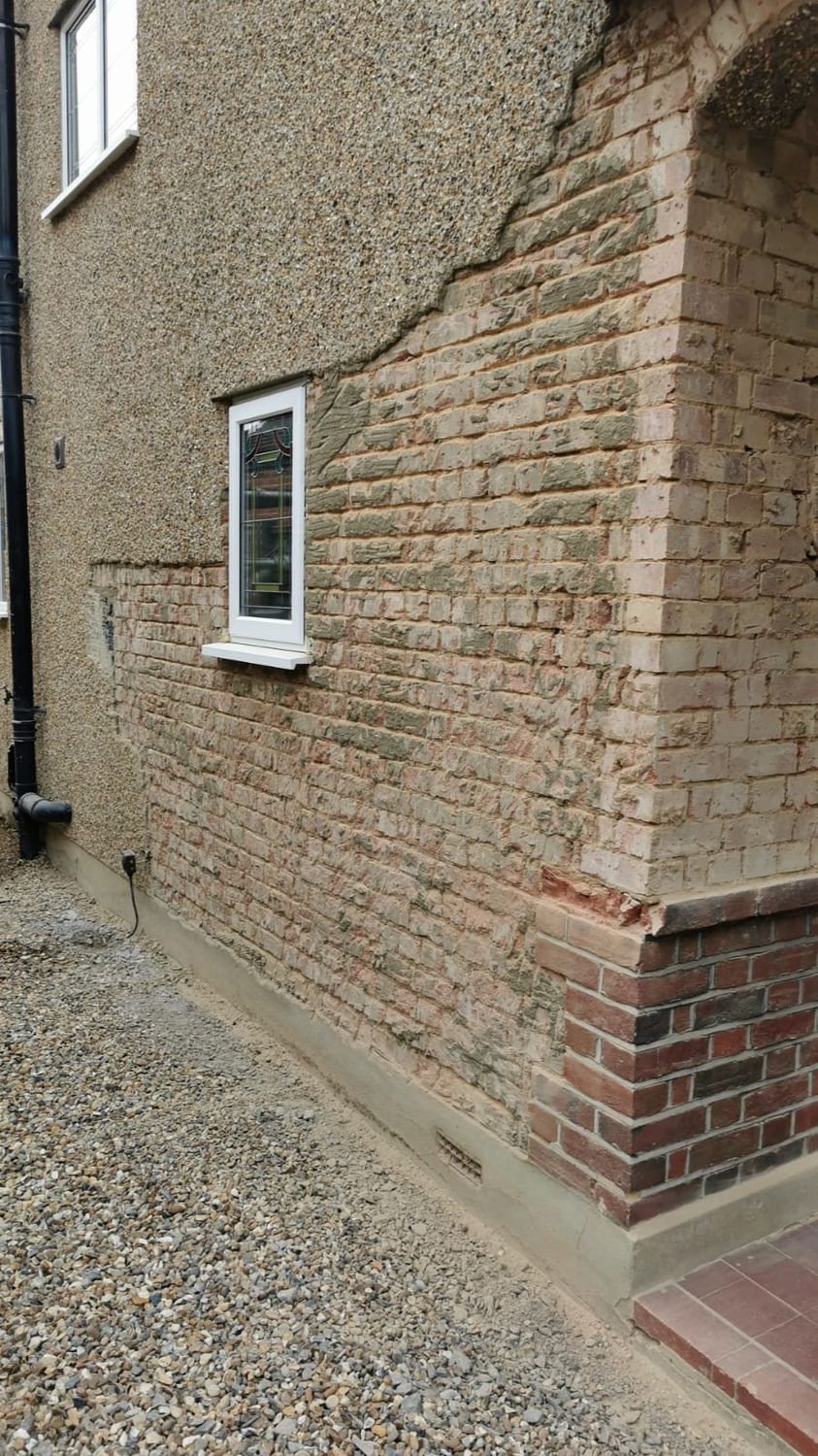 Pebble dash cementitious render being taken down