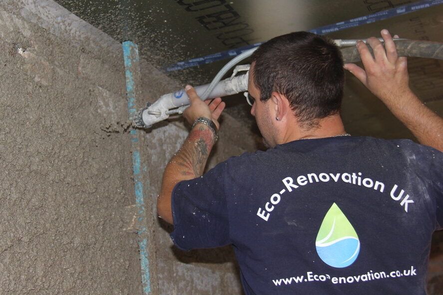 Diathonite Evolution lime-cork-clay insulation plaster being applied with spray pump onto solid masonry walls as internal wall insulation