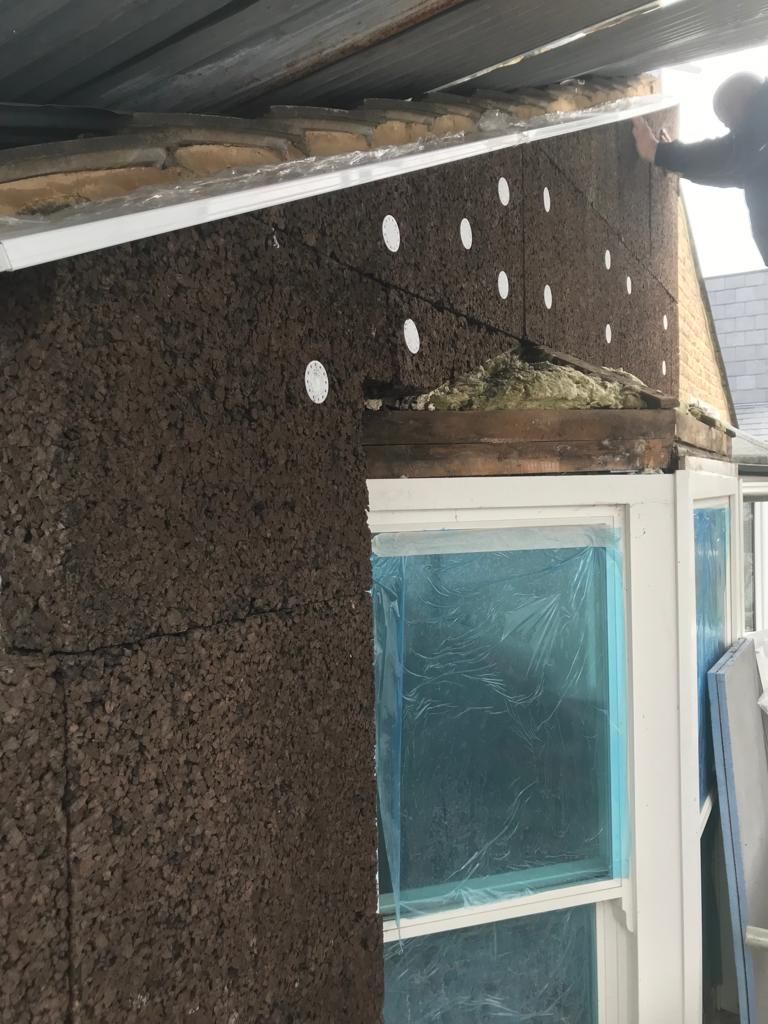 Wall above bay window being insulated