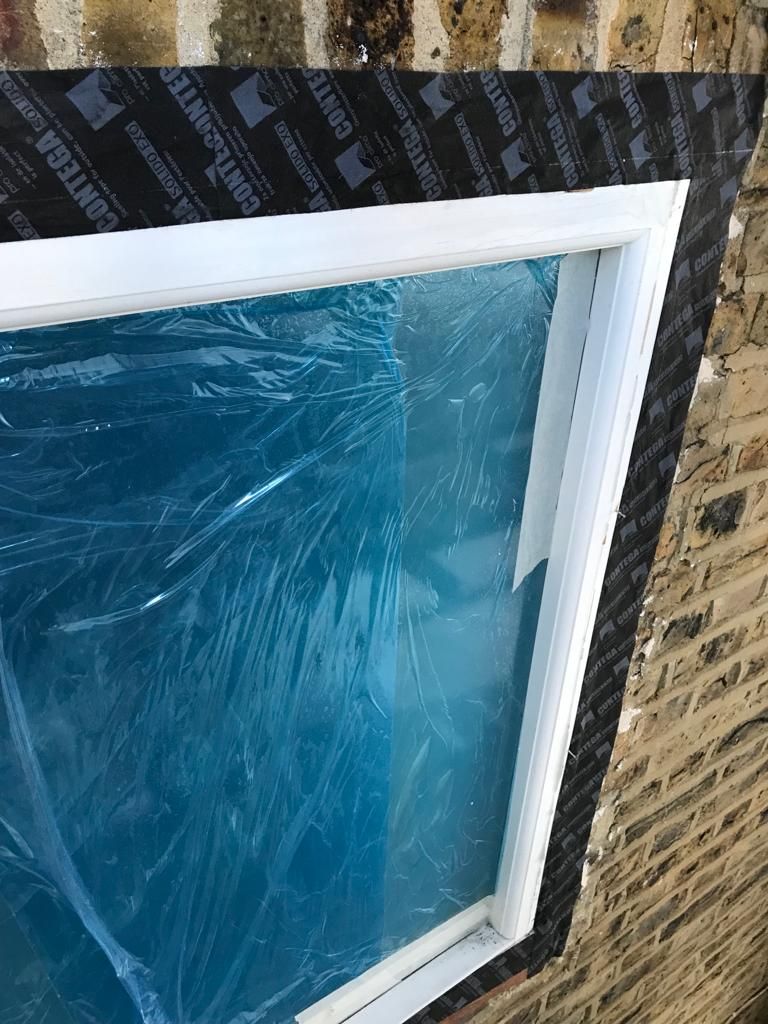Airtightness taping around window frames with Pro Clima Contega Solido Exo