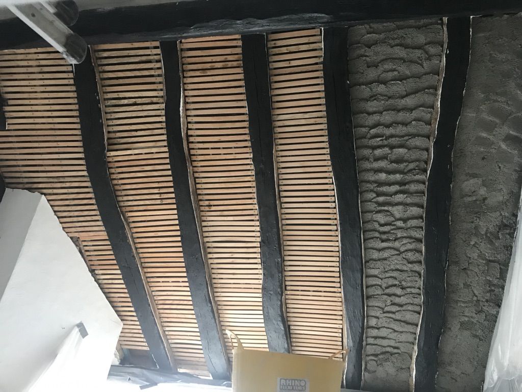 Insulating lime plaster being applied onto lath